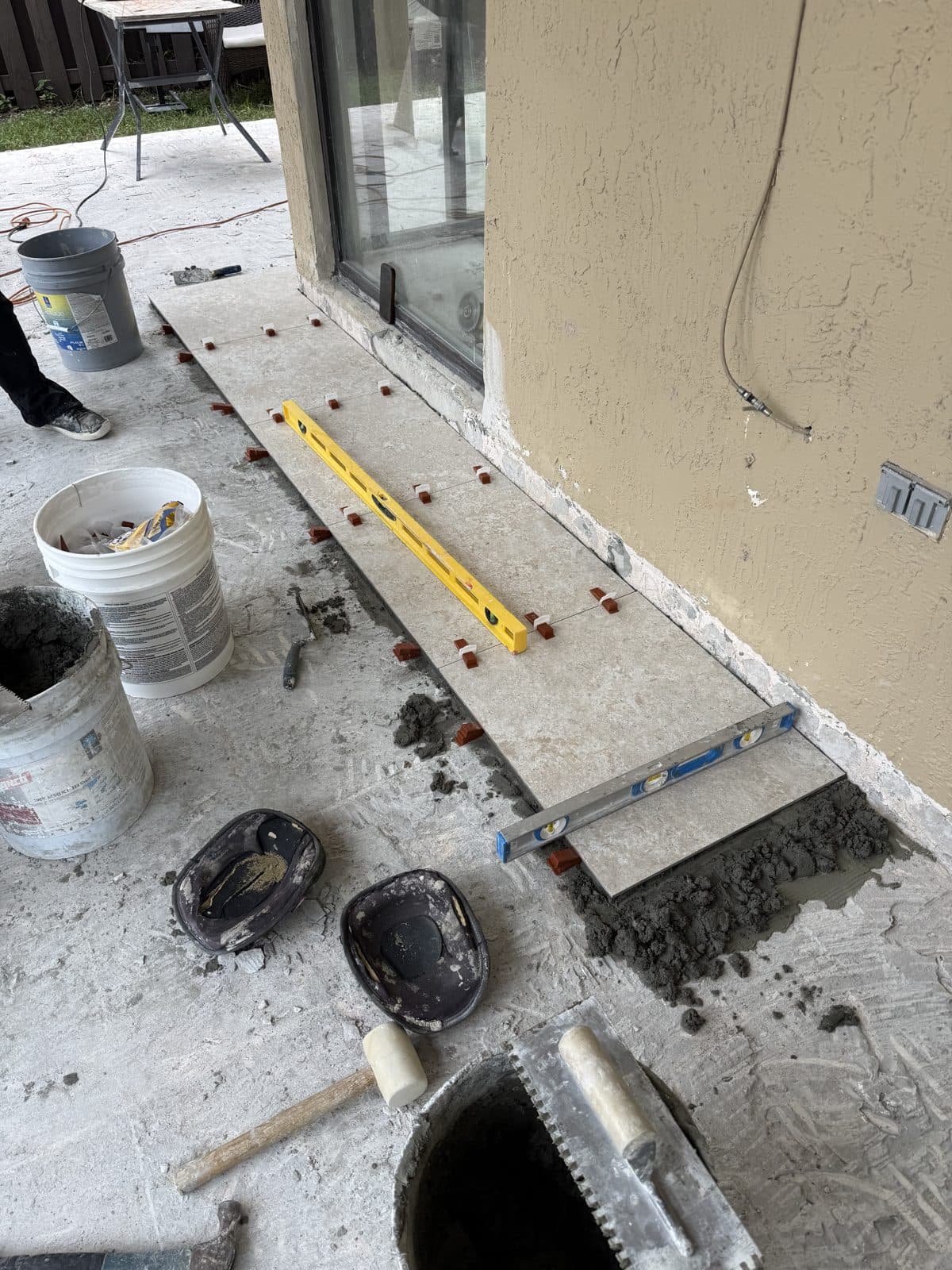 Setting and leveling porcelain tile on a patio in Miami