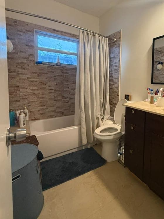 Bathroom with a wall to wall alcove bathtub and shower curtain before conversion in Glenvar Heights