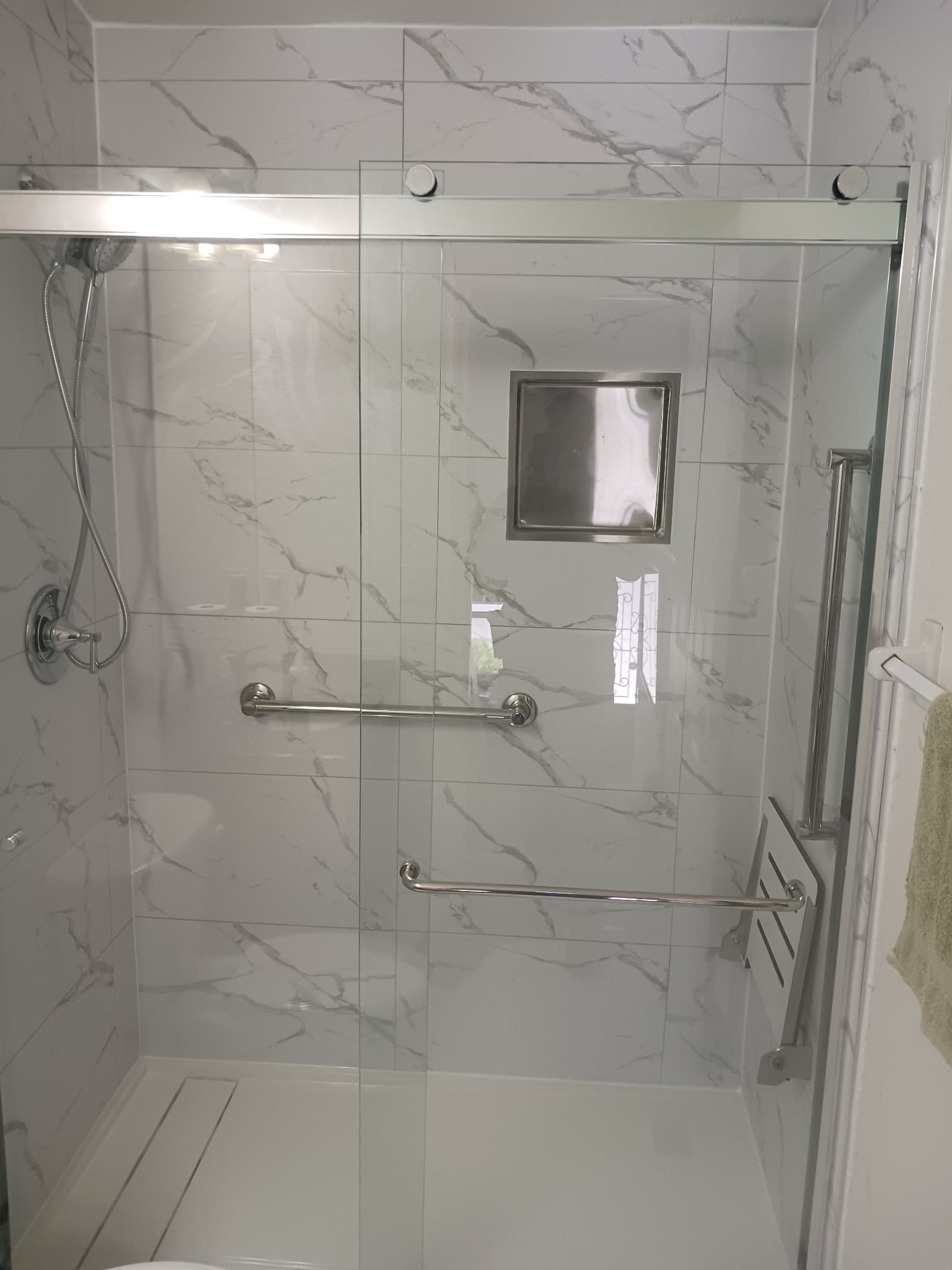 Foto de ducha terminada con azulejo, nicho y barras en un proyecto de The Hammocks