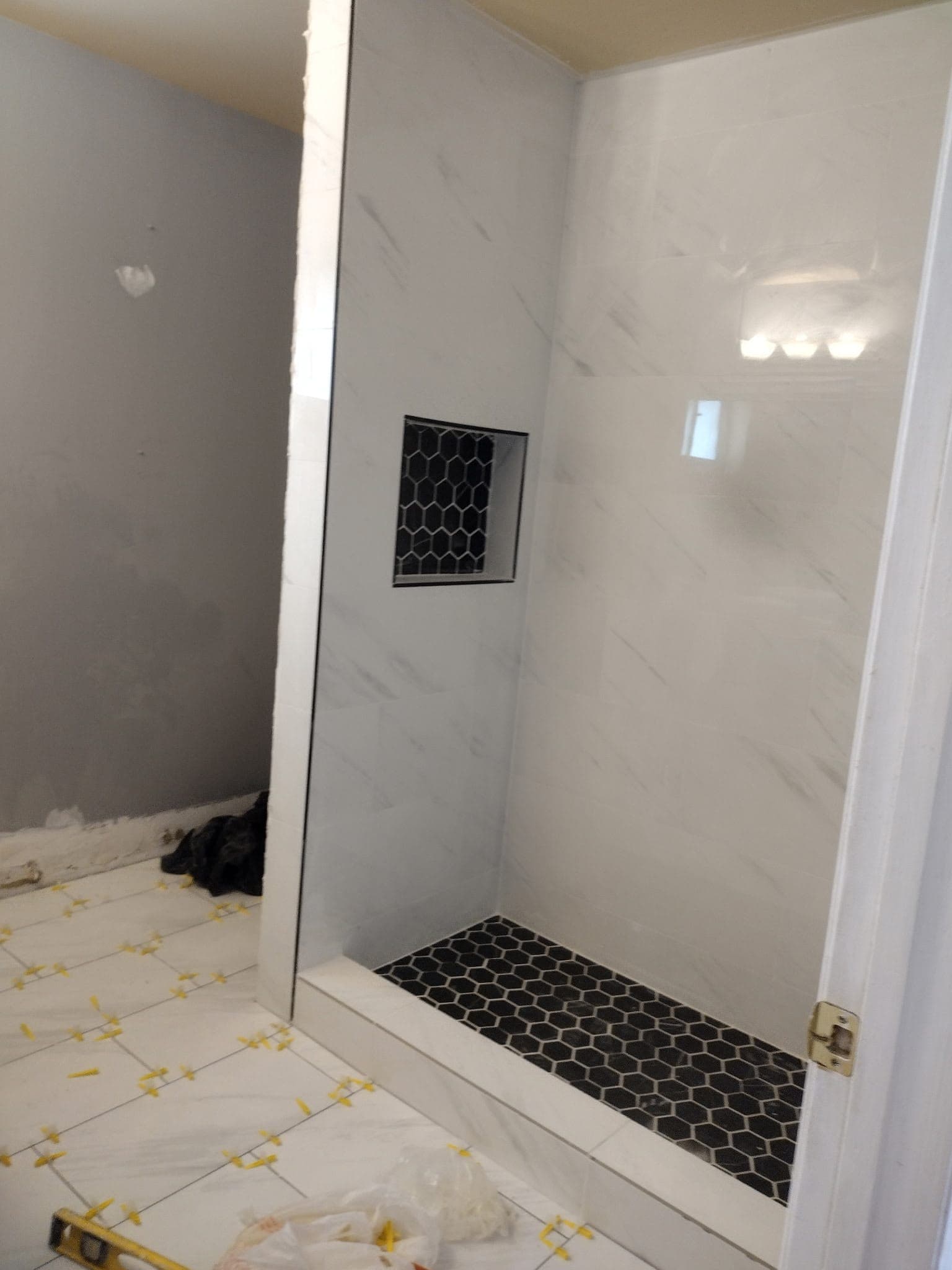 Master bathroom remodel in The Hammocks with a double shower, two rain heads, a tiled bench and a glass divider
